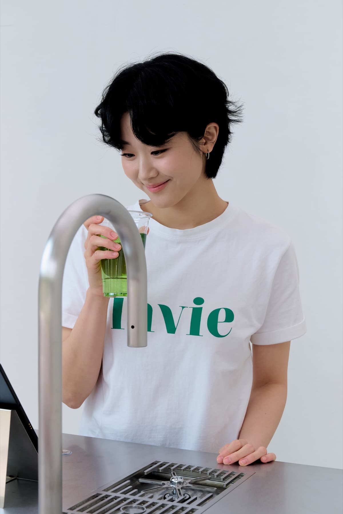 브링크 스테이션 앞에서 음료를 들고 미소 짓는 장면